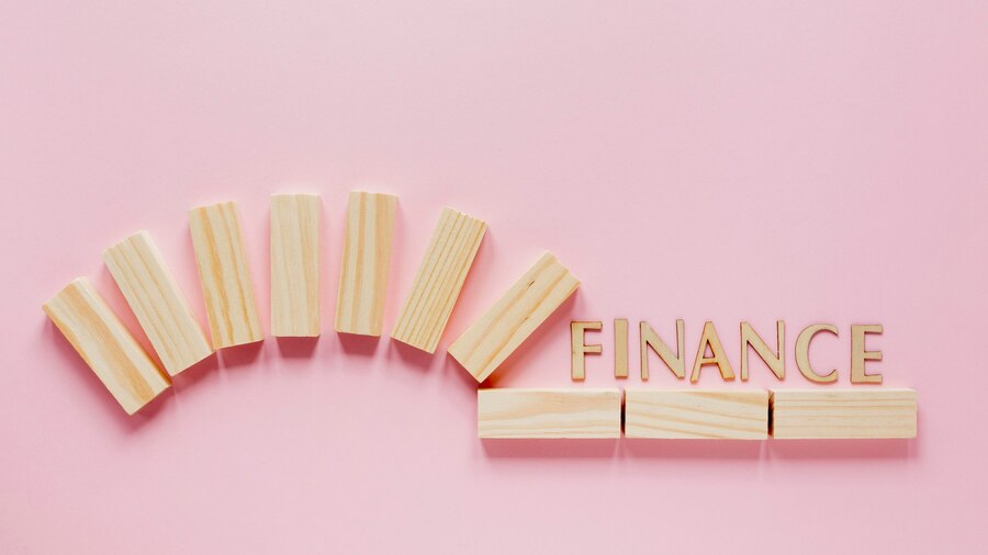 Word Finance in Wooden Blocks at Pink Background