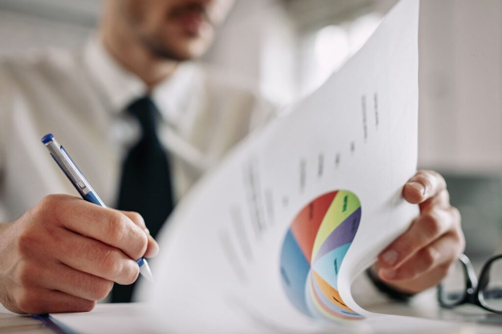 Close up of man going through business reports and taking notes in the office