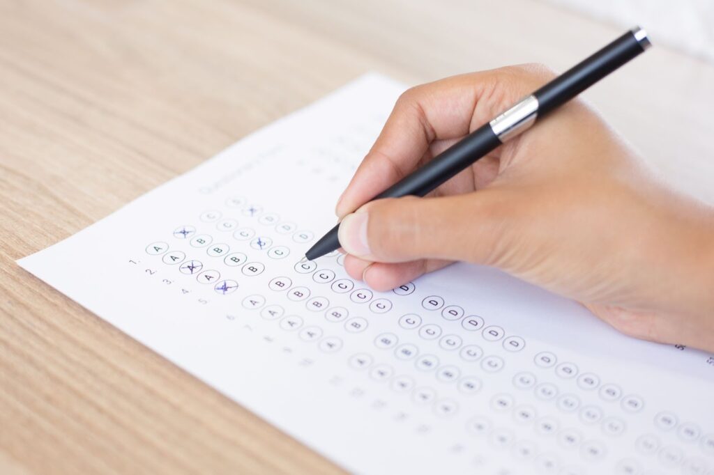 Close up of person filling out exam form