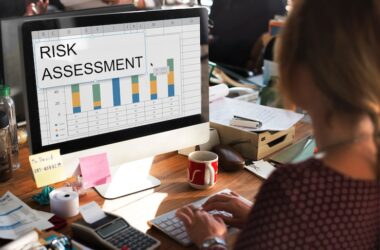 risk management concept photo: a woman sitting and looking at a PC monitor with her hands on the keyboard