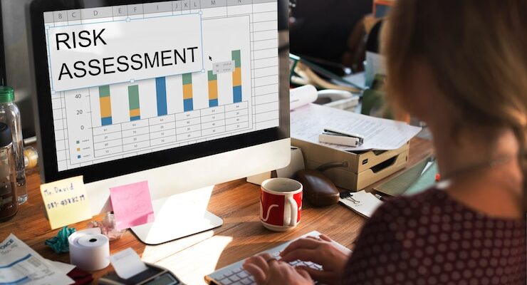 risk management concept photo: a woman sitting and looking at a PC monitor with her hands on the keyboard