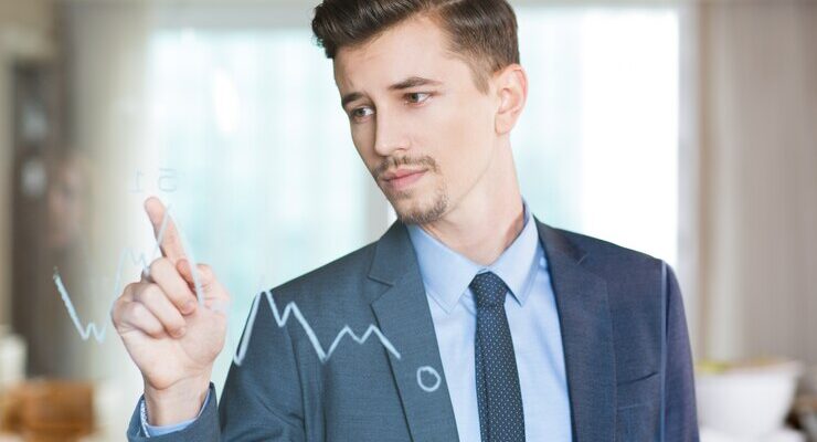 a man in a business suit points his finger at a graph drawn on the glass